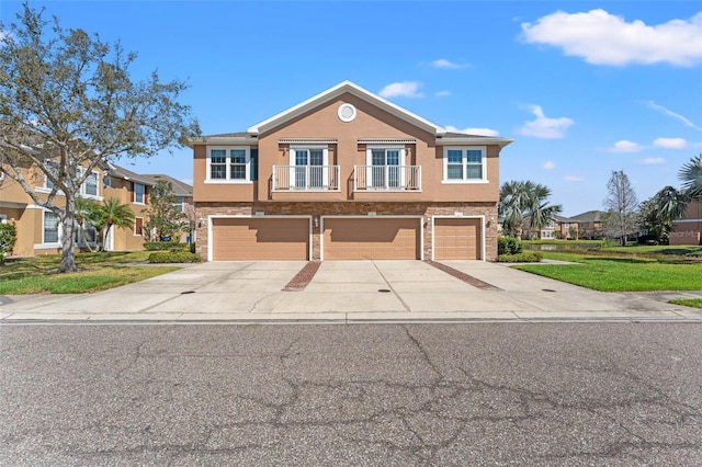 view of front of home featuring concrete driveway, brick siding, an attached garage, and stucco siding