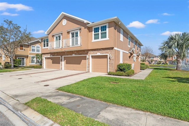 townhome / multi-family property featuring stucco siding, an attached garage, a front yard, stone siding, and driveway