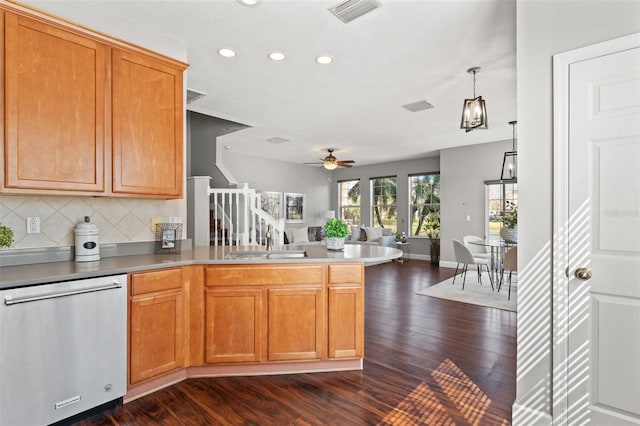 kitchen featuring a peninsula, a sink, visible vents, backsplash, and dishwasher