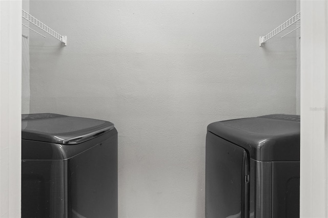 laundry area featuring laundry area, separate washer and dryer, and a textured wall