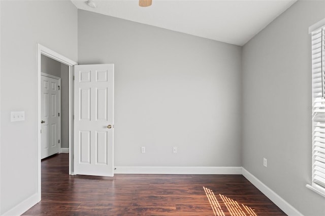 empty room with lofted ceiling, a ceiling fan, baseboards, and wood finished floors