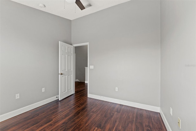 unfurnished room featuring a ceiling fan, visible vents, baseboards, and wood finished floors