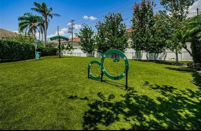 view of home's community with fence and a lawn