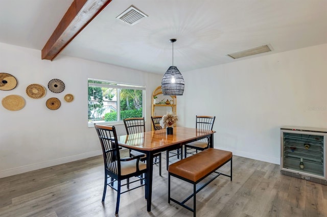 dining space featuring beamed ceiling, wood finished floors, visible vents, and heating unit