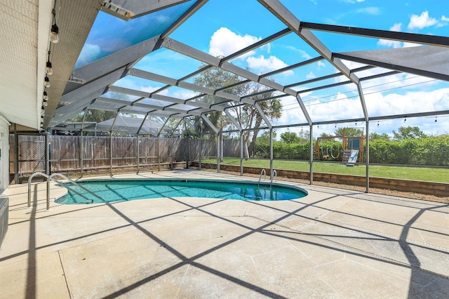 view of swimming pool featuring glass enclosure, a patio area, and a fenced in pool