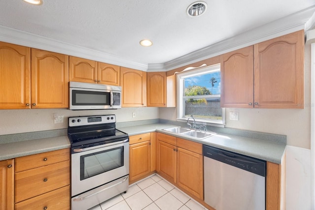 kitchen featuring light tile patterned floors, light countertops, appliances with stainless steel finishes, and a sink