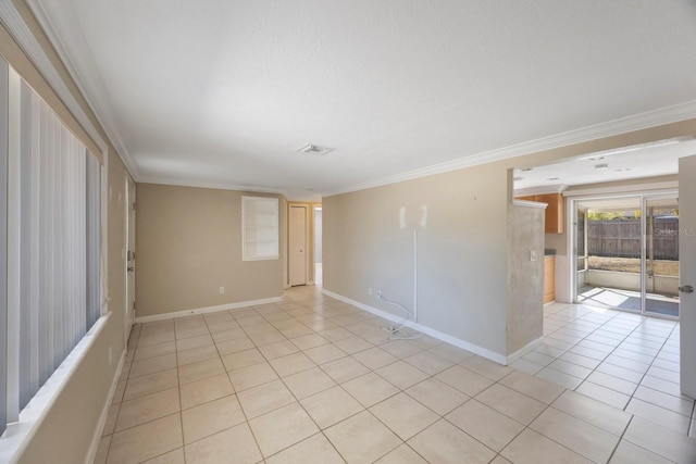 spare room featuring light tile patterned floors, a textured ceiling, visible vents, baseboards, and crown molding