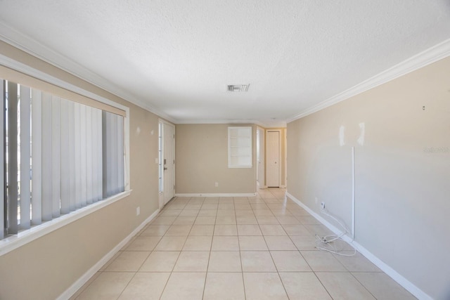 spare room featuring light tile patterned floors, baseboards, visible vents, ornamental molding, and a textured ceiling