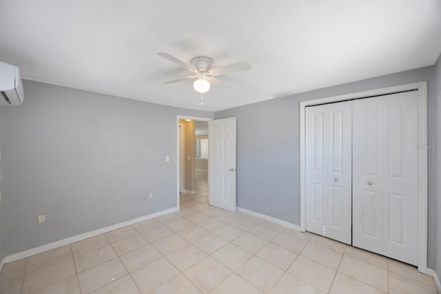 unfurnished bedroom featuring a closet, a wall mounted AC, light tile patterned flooring, ceiling fan, and baseboards