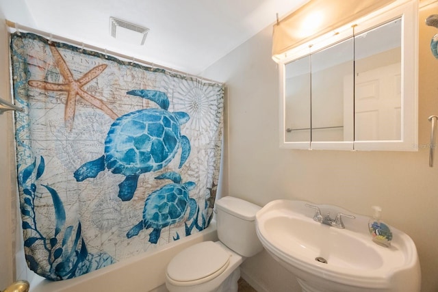 bathroom featuring toilet, visible vents, shower / bath combo with shower curtain, and a sink