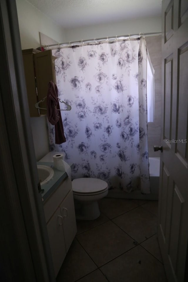 full bathroom with shower / bath combo, toilet, tile patterned floors, a textured ceiling, and vanity