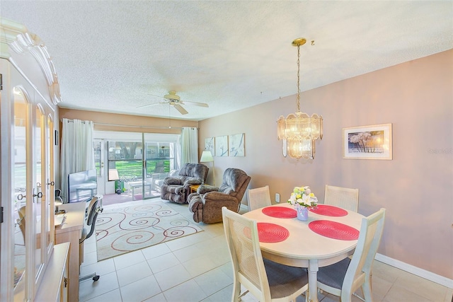 dining space featuring light tile patterned flooring, a textured ceiling, baseboards, and ceiling fan with notable chandelier