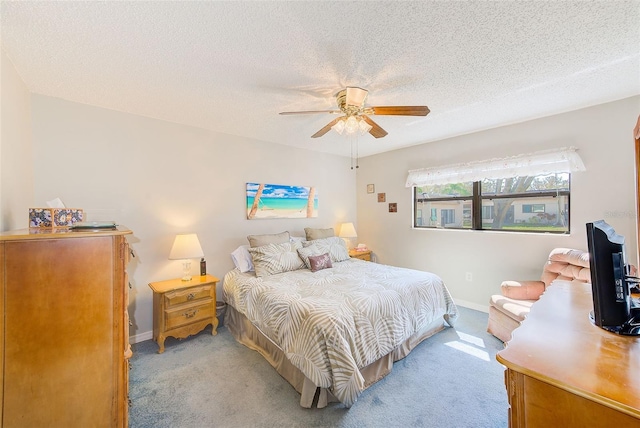 bedroom with a ceiling fan, light colored carpet, a textured ceiling, and baseboards