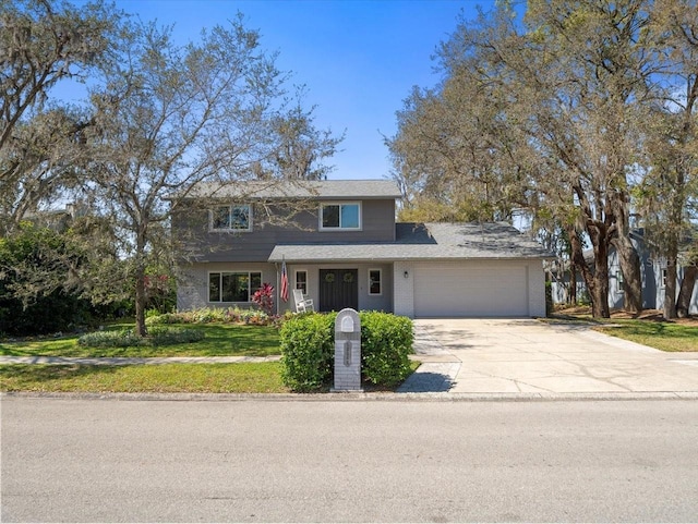 traditional-style house with a garage, driveway, brick siding, and a front yard