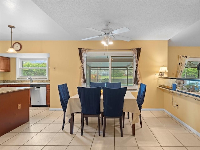 dining area with light tile patterned floors, a textured ceiling, and baseboards