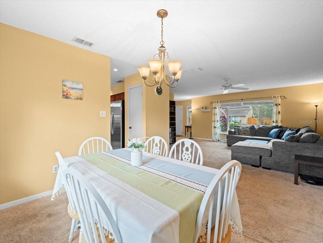 dining area with light carpet, ceiling fan with notable chandelier, visible vents, and baseboards