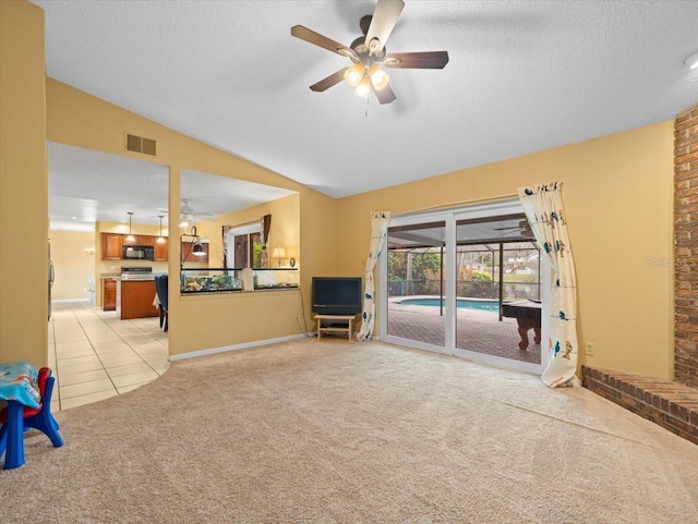 living room with light carpet, a textured ceiling, lofted ceiling, and visible vents