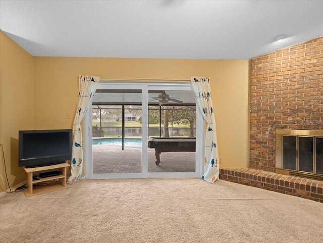 unfurnished living room with carpet, a brick fireplace, and a textured ceiling