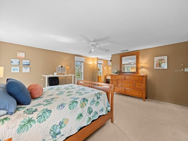 bedroom with visible vents, ceiling fan, light carpet, and a textured ceiling