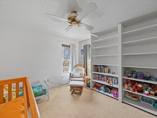 carpeted bedroom featuring ceiling fan and a textured ceiling