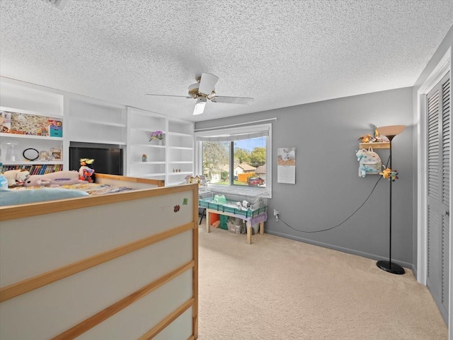 carpeted bedroom featuring a closet, ceiling fan, and a textured ceiling