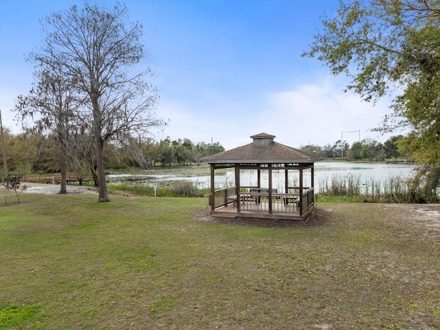 dock area featuring a gazebo, a lawn, and a water view