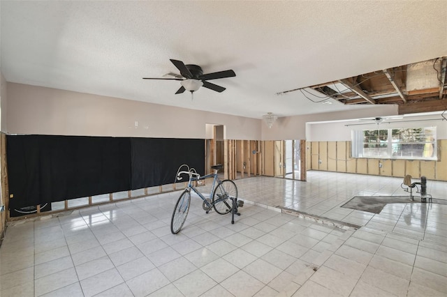 interior space featuring ceiling fan, a textured ceiling, and tile patterned floors