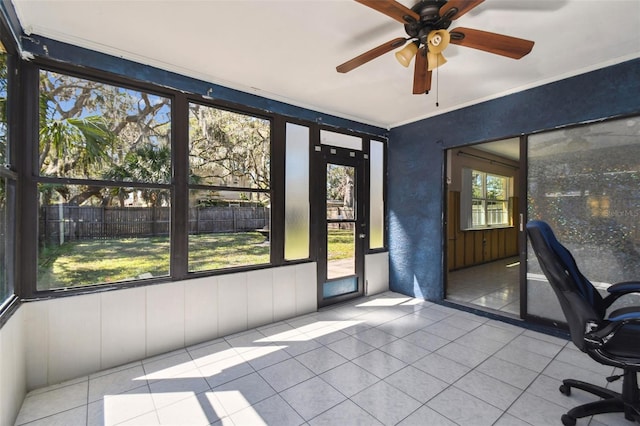 unfurnished sunroom with a ceiling fan