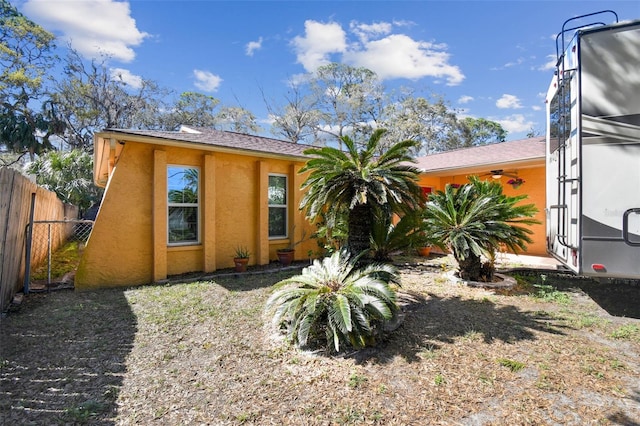 view of front facade with fence and stucco siding