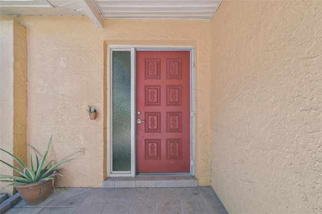 property entrance with visible vents and stucco siding