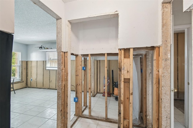 miscellaneous room with light tile patterned floors and a textured ceiling