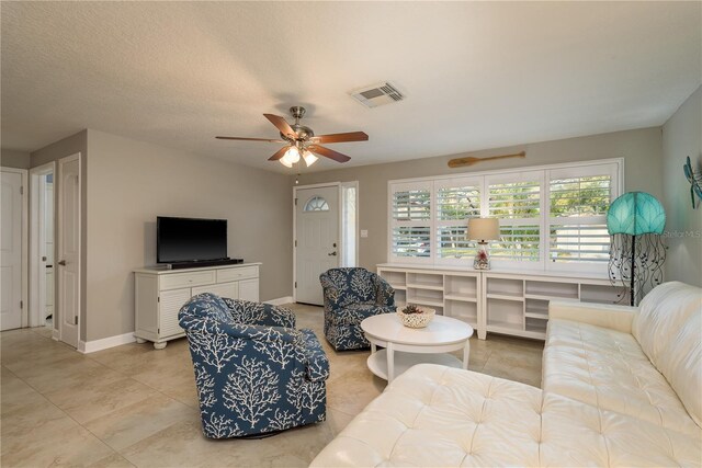 living room with ceiling fan, light tile patterned floors, and baseboards