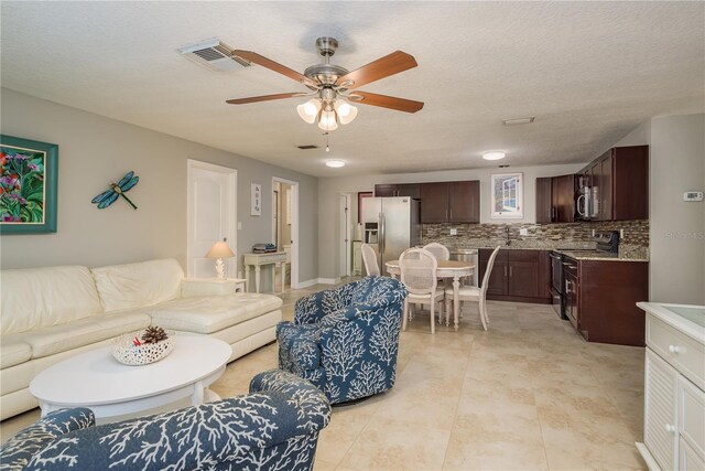 living room with a ceiling fan and light tile patterned floors