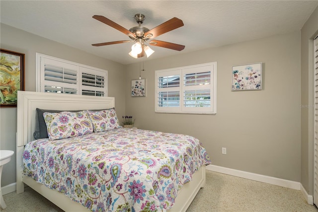 bedroom featuring baseboards, speckled floor, and ceiling fan