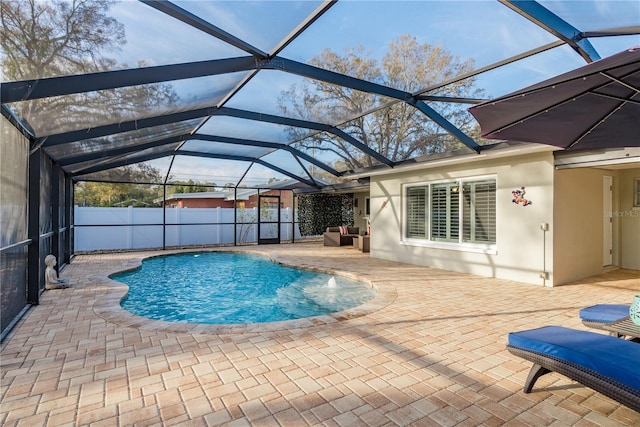 view of swimming pool featuring a patio, a lanai, and fence