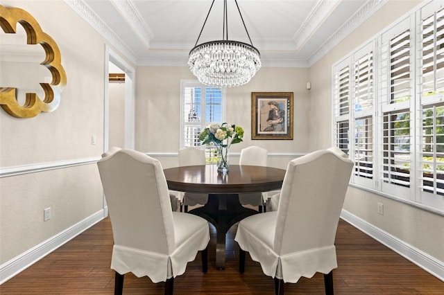 dining area featuring a tray ceiling, baseboards, wood finished floors, and ornamental molding