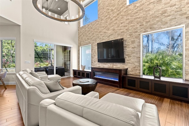 living room featuring baseboards, wood-type flooring, and a glass covered fireplace