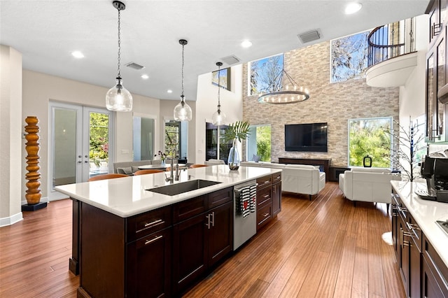 kitchen with a sink, visible vents, open floor plan, and light countertops