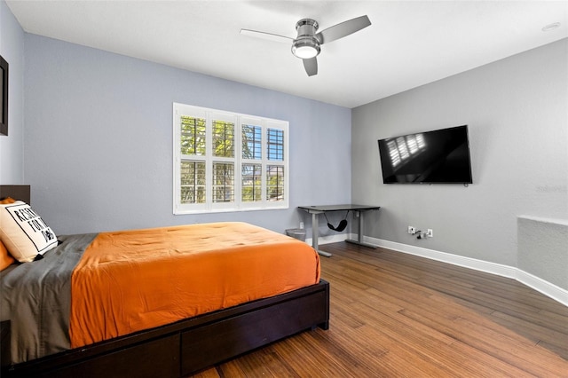 bedroom with a ceiling fan, baseboards, and wood finished floors