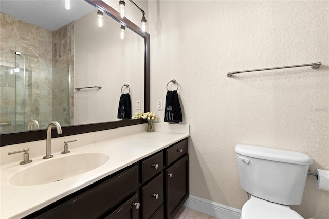 bathroom featuring tile patterned flooring, baseboards, toilet, a tile shower, and vanity