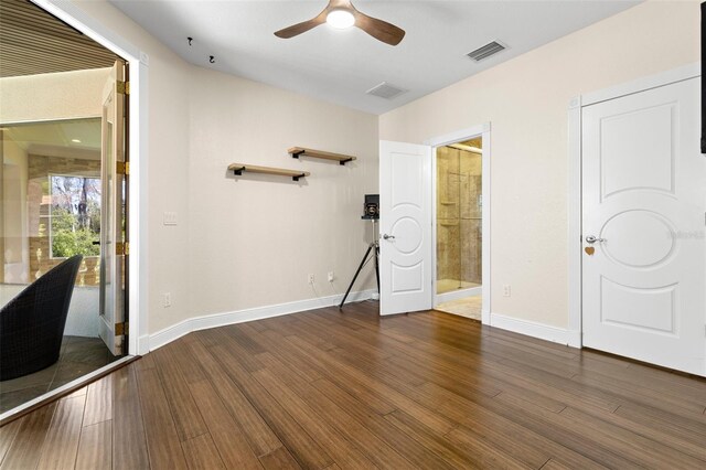 unfurnished bedroom featuring ceiling fan, visible vents, baseboards, and wood finished floors