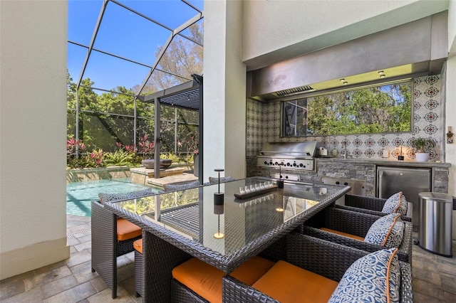 exterior space featuring an outdoor pool, glass enclosure, area for grilling, and exterior kitchen