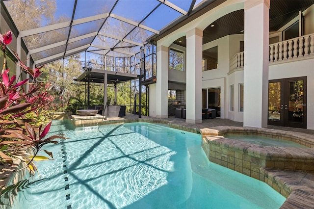 view of pool featuring a patio, french doors, a pool with connected hot tub, and a lanai