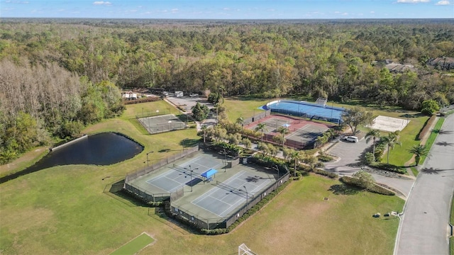 birds eye view of property with a view of trees and a water view