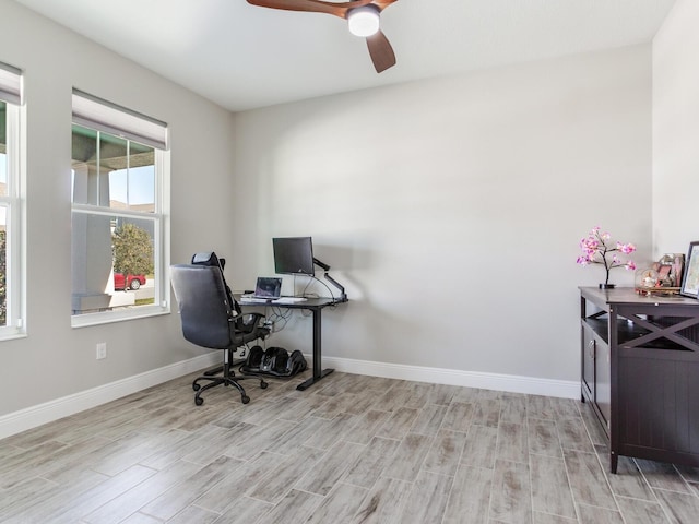 office featuring baseboards, a ceiling fan, and light wood-style floors