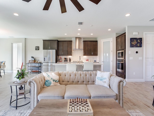 living area with recessed lighting, visible vents, ceiling fan, light wood-type flooring, and baseboards