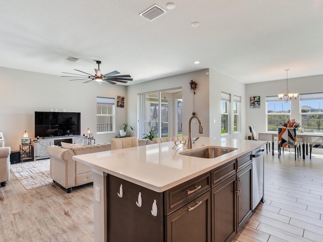 kitchen featuring dishwasher, light countertops, a sink, and visible vents