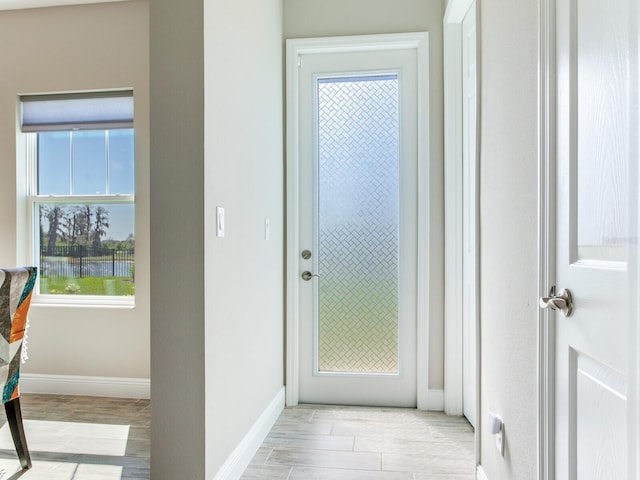 doorway to outside with wood tiled floor and baseboards
