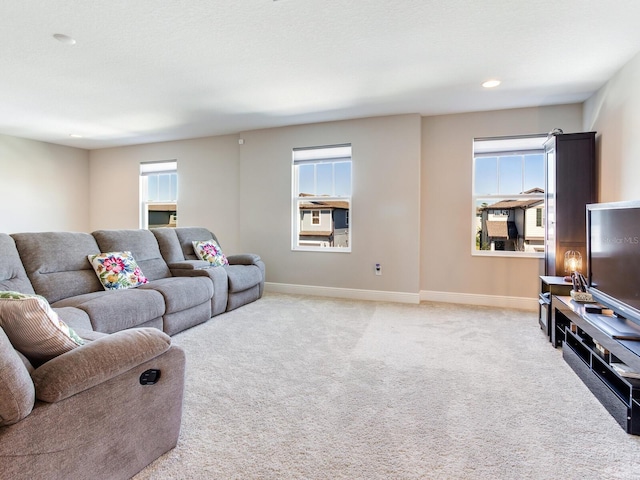 living area featuring light carpet, recessed lighting, and baseboards