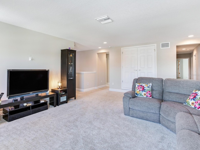 living room with light colored carpet, visible vents, baseboards, and recessed lighting